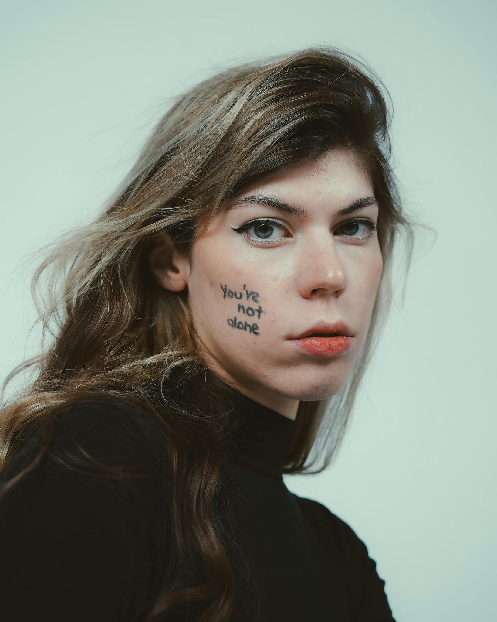 Close-up portrait highlighting mental health awareness with 'You're not alone' message.