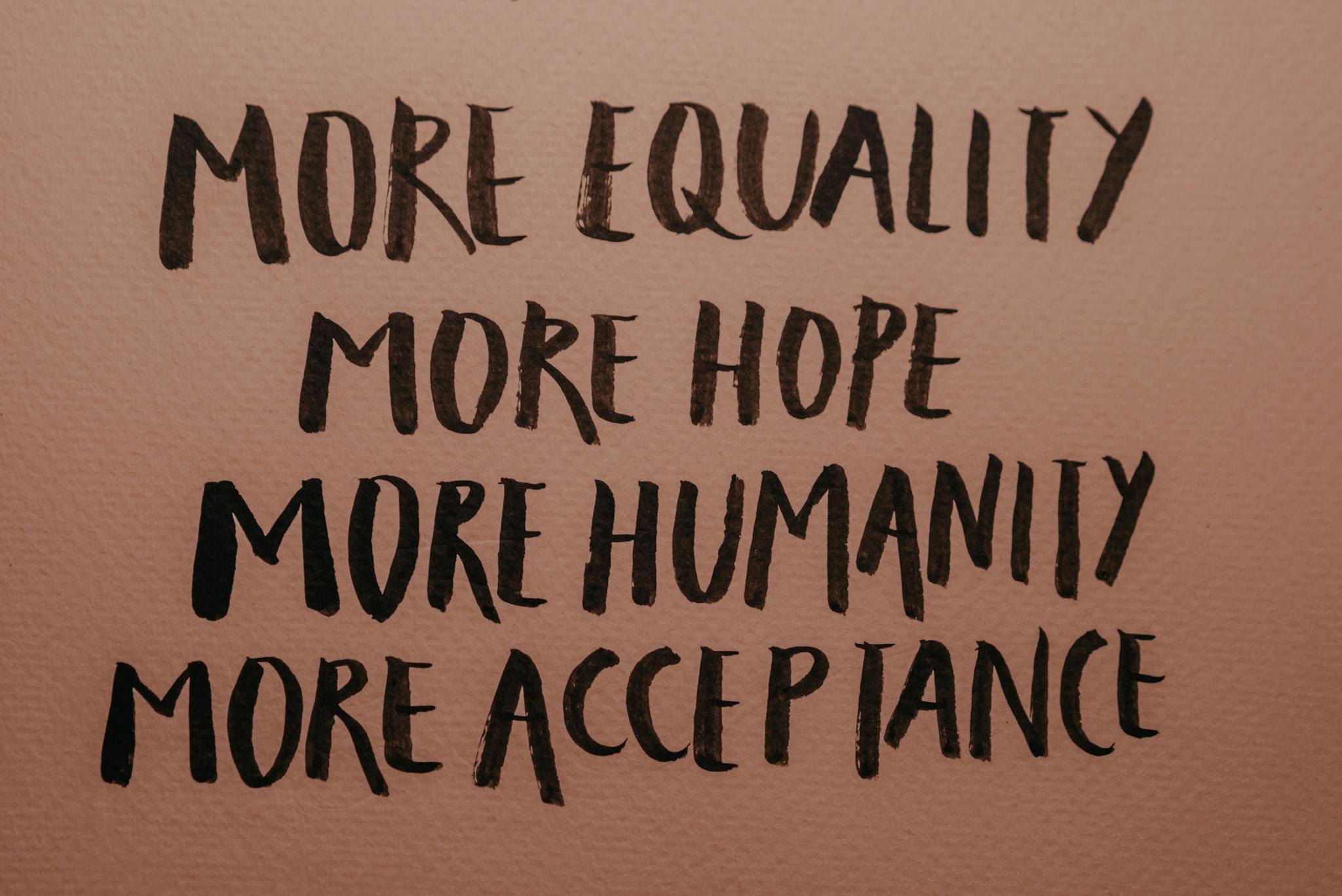 Handwritten motivational phrases promoting equality, humanity, hope, and acceptance.