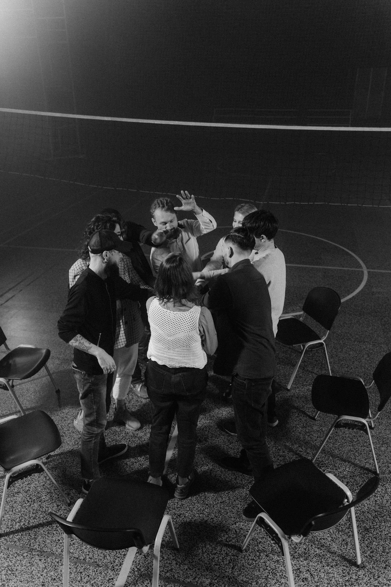 A group of individuals engaged in a discussion circle, captured in dynamic black and white.